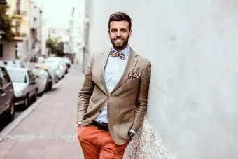 Homme assis devant une sculpture de la ville