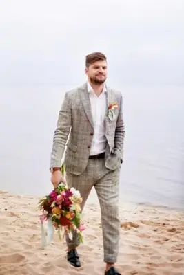 Marié souriant marchant à la plage contre un ciel clair pendant une journée ensoleillée