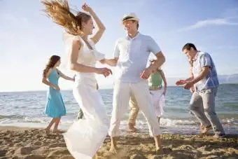 Couple de jeunes mariés sur la plage avec des amis