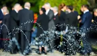 אנשים מטושטשים לובשים חליפות שחורות בעקבותיהם