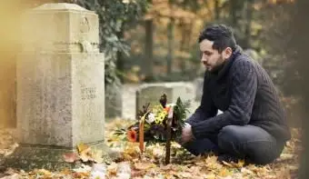 묘지에서 무덤을 방문하는 꽃과 촛불 중반 성인 남자