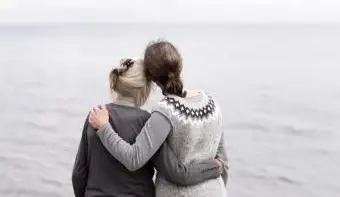 Due generazioni di donne che si abbracciano, guardando il mare