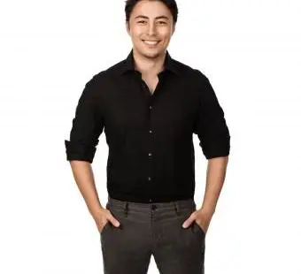 גבר בחולצה שחורה ומכנסיים אפורים