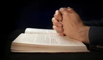 祈りながら聖書に手を握りしめた