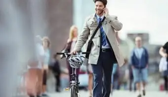 携帯電話で話している自転車を持つビジネスマン