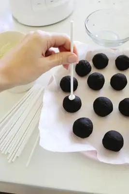 Sticking sticks into Oreo cake balls