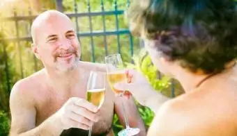 nudisti che brindano all'aperto