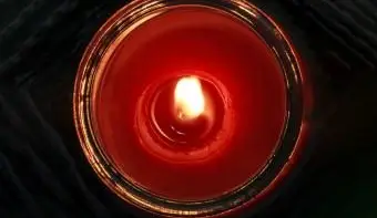 Brennende rote Kerze in einem Glasgefäß direkt von oben gesehen