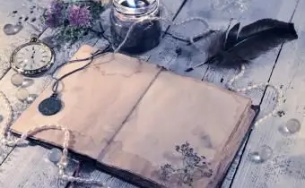 Diario aperto con orologio, candela nera, penna d'oca e medaglione