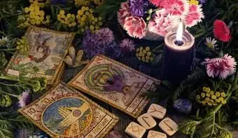 古いタロットカード、紫色のキャンドル、ルーン文字、花のある静物