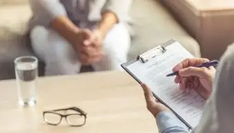 Psychothérapeute prenant des notes tout en écoutant son patient