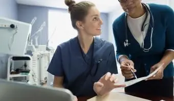 Médecin et infirmière discutant des dossiers médicaux