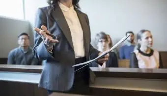 法廷で話したり身振りをしたりする女性弁護士