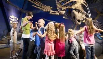 Travailleur de musée avec des enfants au musée d'histoire naturelle