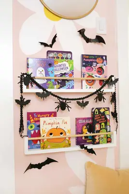 bookcase with halloween books on it and halloween decorations around it