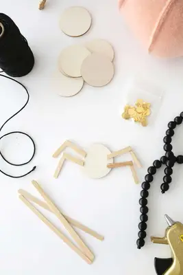 wooden circle with four wooden spider legs glued to it