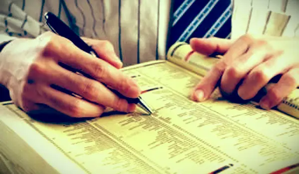 Empresario buscando en páginas amarillas