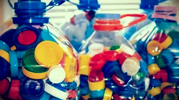 Fľaše plné farebných plastových uzáverov fliaš