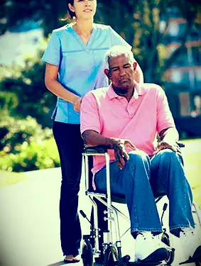 Mann im Rollstuhl schieben