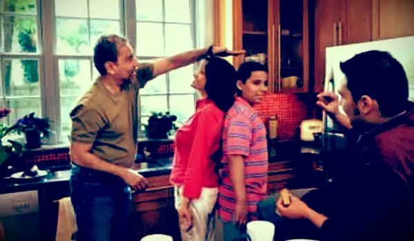 El abuelo compara la altura de la abuela y los nietos