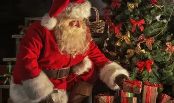 Der Weihnachtsmann legt Geschenke unter den Baum