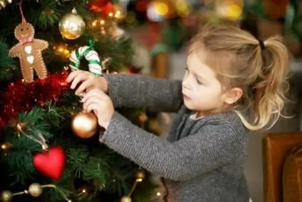 Mała dziewczynka trzyma bombkę na choinkę