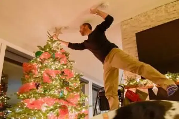 집에서 크리스마스 트리를 장식하는 남자