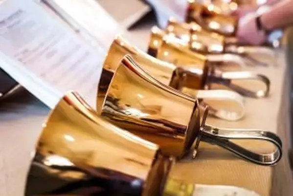 Goldene Handglocken auf Tisch mit Notenblatt