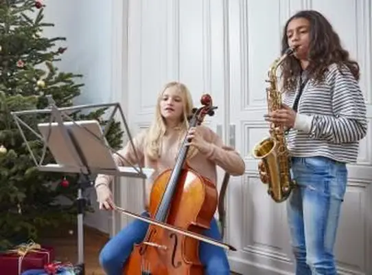 Deux filles jouant du violoncelle et du saxophone à Noël