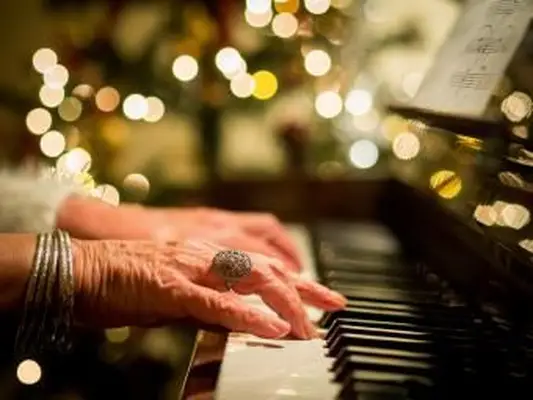 Femme jouant des chants de Noël sur un piano