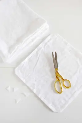 several pieces of cotton fabric with gold scissors on top
