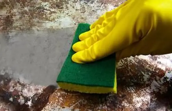 汚れた金属表面をこすり洗いする