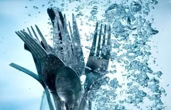 Lavando utensílios de cozinha em água limpa