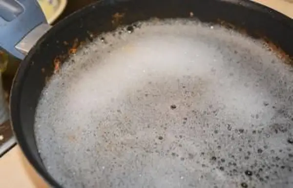 Remojar la olla en agua y jabón.