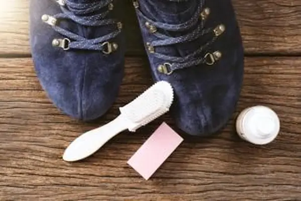 Femme nettoyant les bottes en daim pour les soins d'hiver