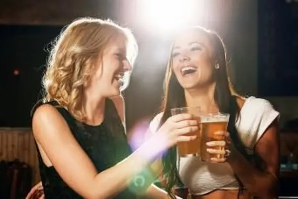 Mujeres disfrutando de sus bebidas juntas en una discoteca