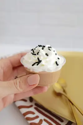 chocolate pudding shot with whipped cream and sprinkles