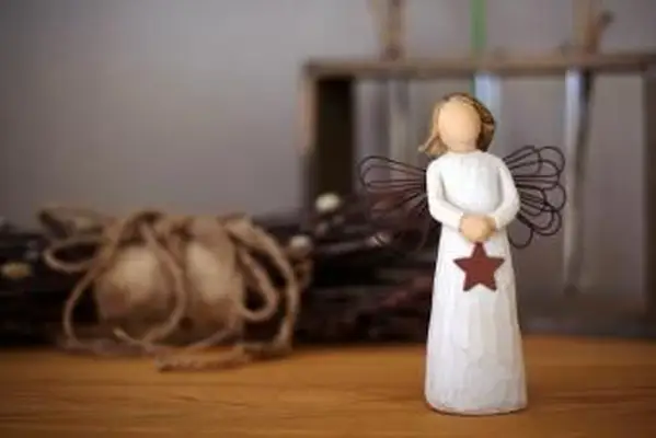 Pequeña figura de ángel de madera sobre mesa