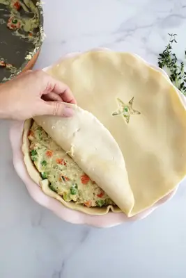 adding top crust to chicken pot pie