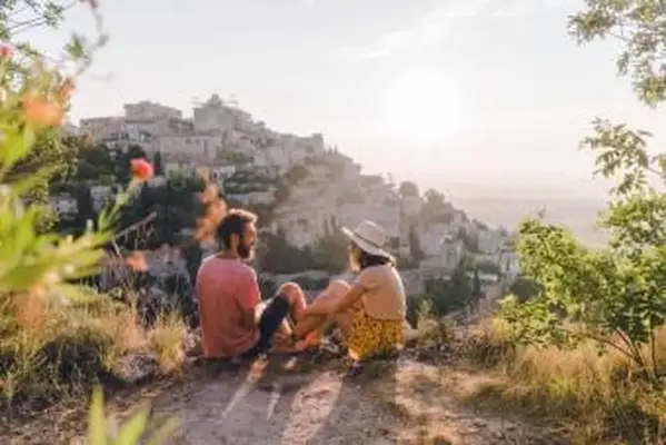 Donna e uomo che guardano la vista panoramica del villaggio di Gordes in Provenza