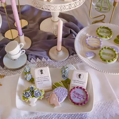 Bridgerton-inspired royal icing cookies displayed on table
