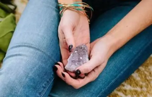 Frau sitzt mit einem Amethyst