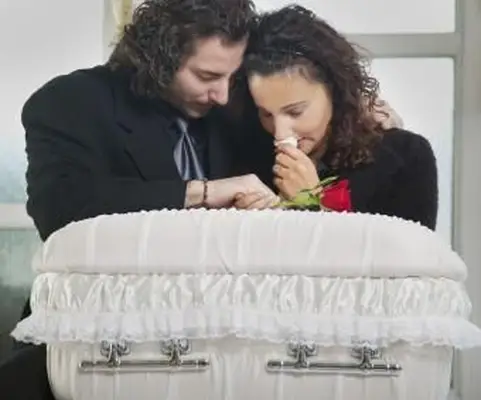 유아 관에 슬퍼하는 부모