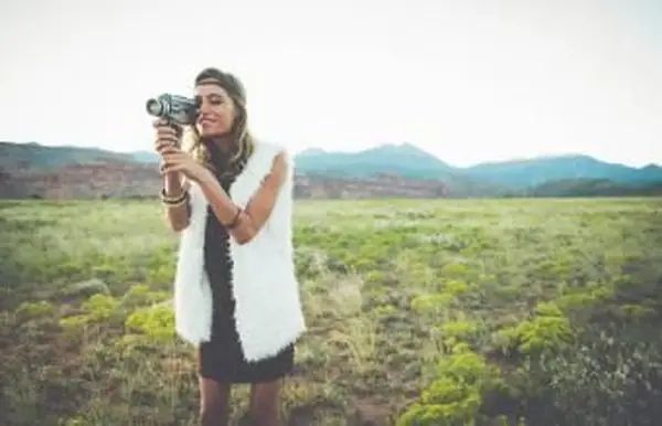 mujer filmando en campo rural