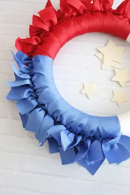 blue ribbons being tied onto a ribbon wreath