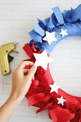 attaching white stars on ribbon wreath