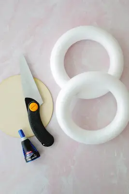foam wreath rings, a wooden circle, and glue and a hand saw
