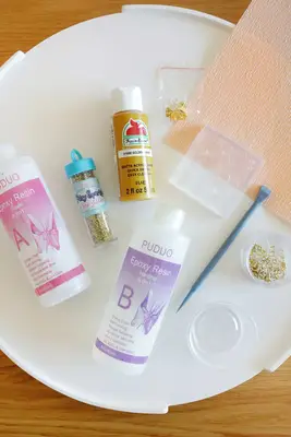 resin, glitter, paint, and jewelry supplies to make earrings