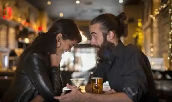 Coppia che parla a tavola con cocktail e birra