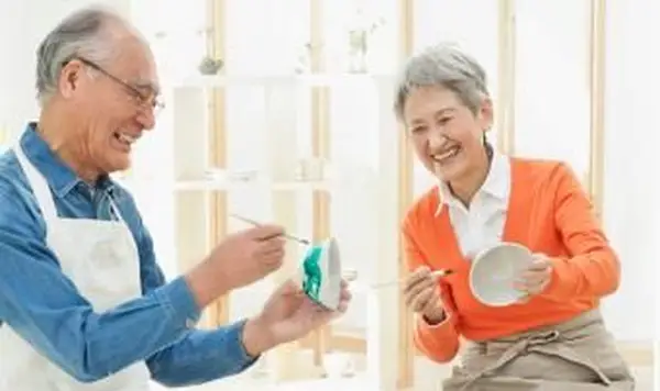 Casal de idosos pintando louça de barro